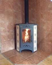 Недорогая печь-камин Бавария угловая с плитой незабудка Амазонка бай фото в интерьере в Витебске