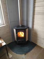 Недорогая печь-камин со стеклом Бавария угловая с плитой фото в интерьере в Витебске